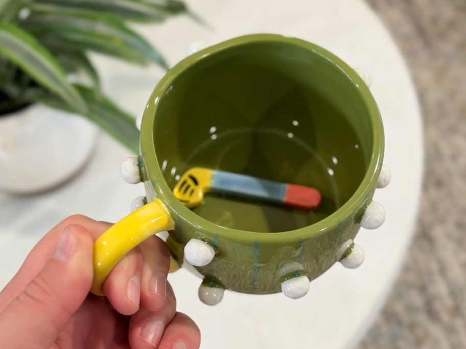 hand holding green mug 