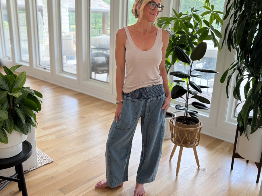woman wearing white tank top and blue barrel jeans 