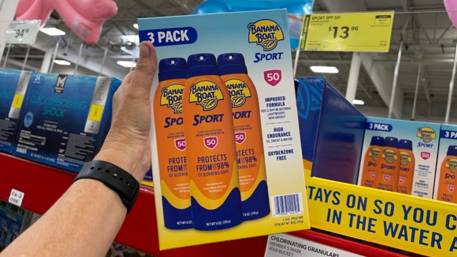 hand holding a 3 pack of suncreen