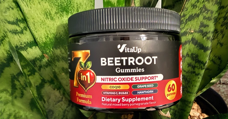 container of beetroot gummies in front of a plant