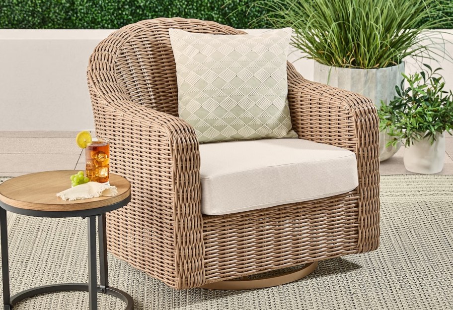 wicker arch chair with white cushions on patio