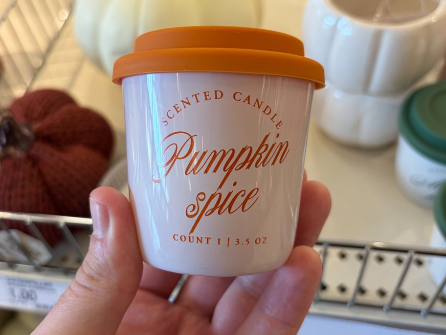 hand holding scented pumpkin spice candle 