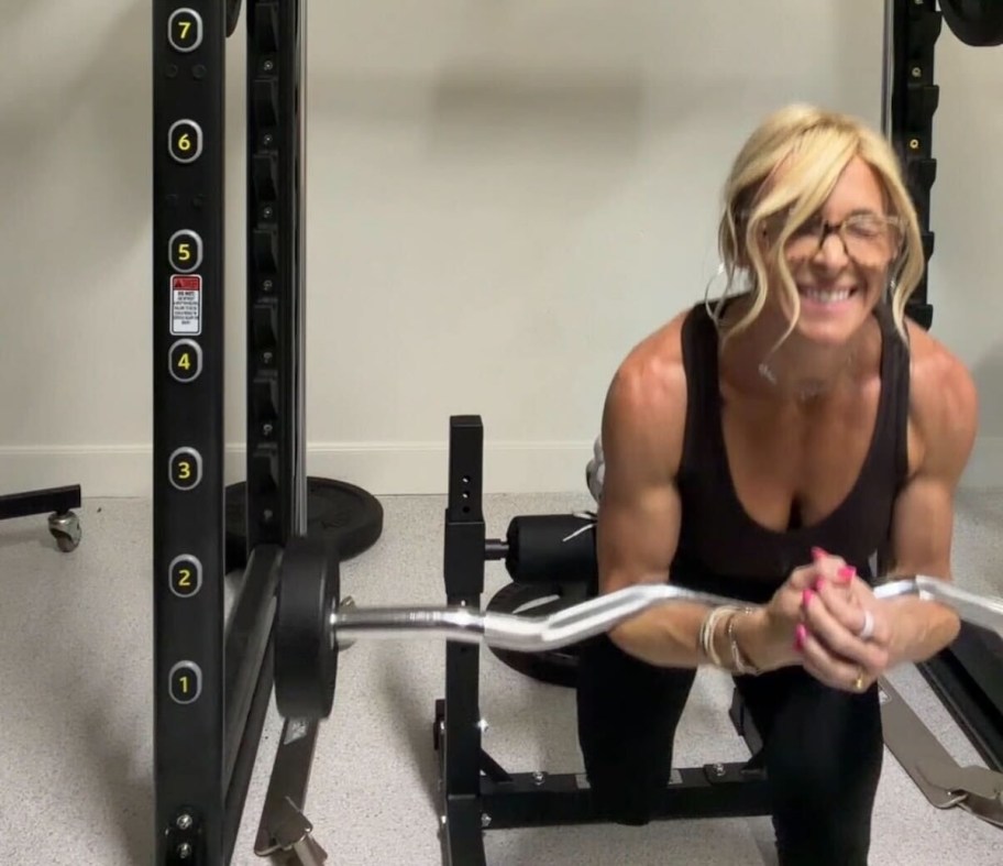 woman with weight bar in pull up rack