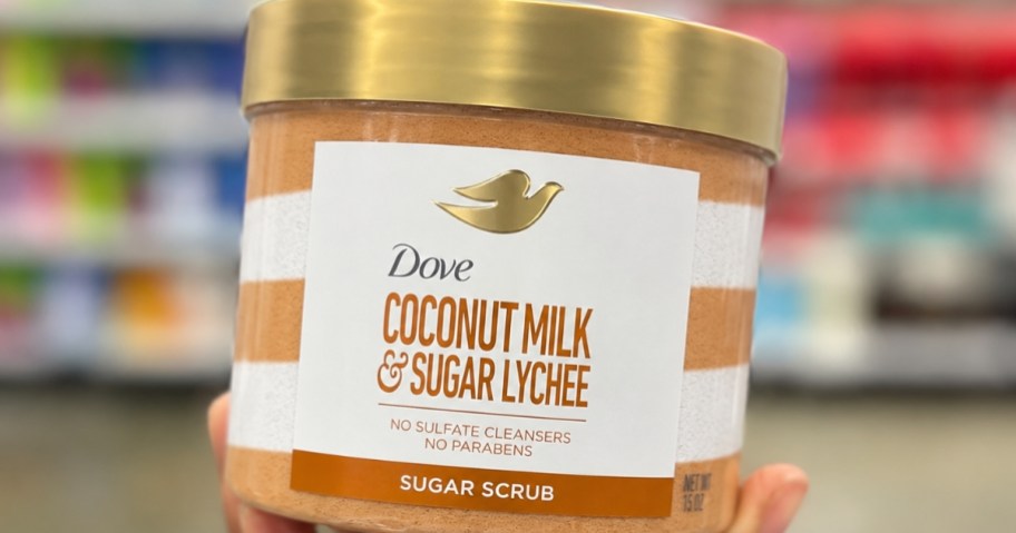 hand holding a jar of Dove Sugar Body Scrub