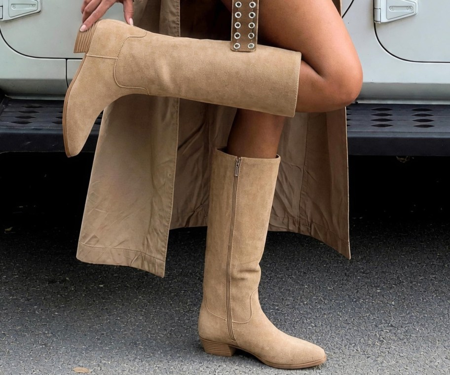 woman wearing tan boots next to parked car