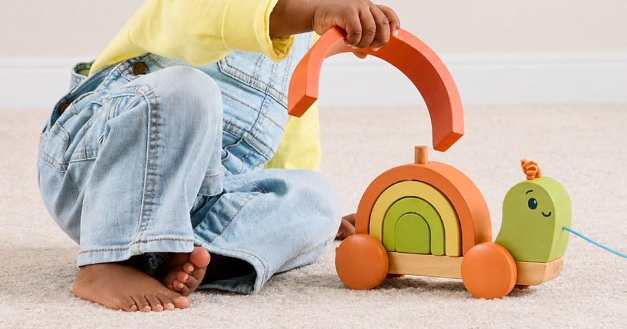child playing with wooden pull toy