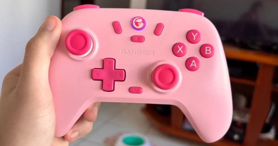 A pink gaming controller with various buttons, including the letters A, B, X, and Y.