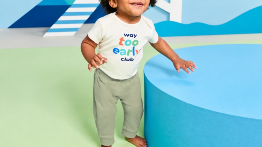 a toddler boy standing by a round table