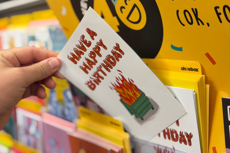 hand grabbing dumpster fire card