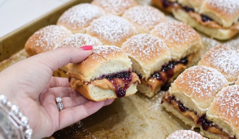 hand grabbing pb&j slider off sheet pan