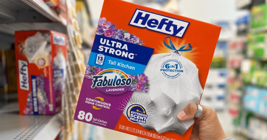 hand holding a box of Hefty trash bags in a store aisle