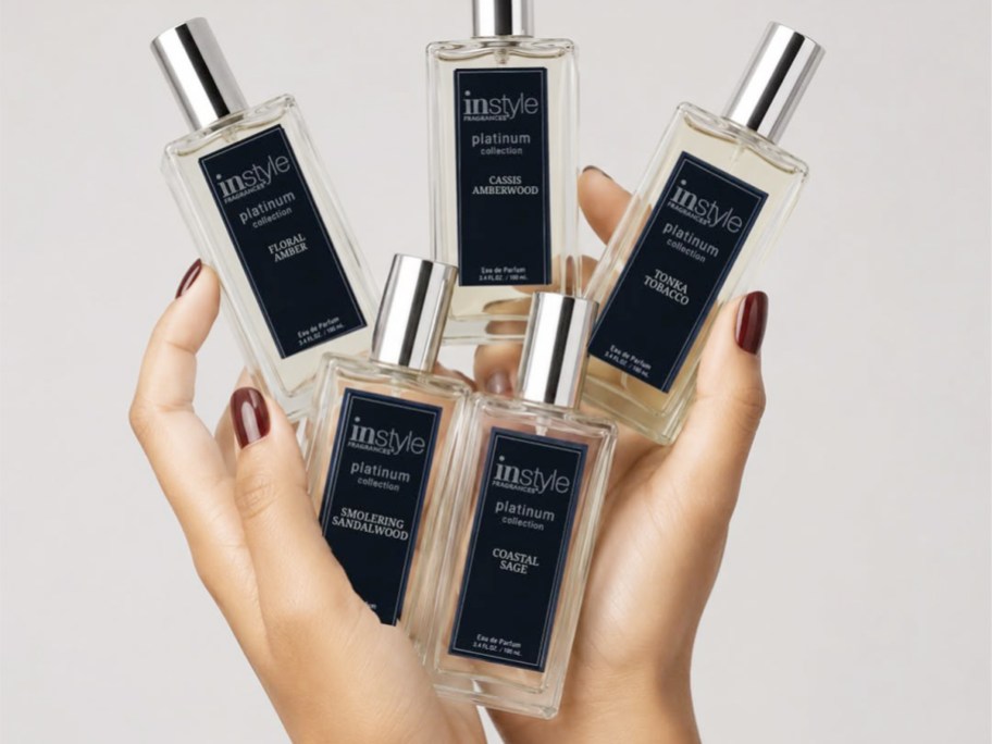 hands holding in style fragrance bottles