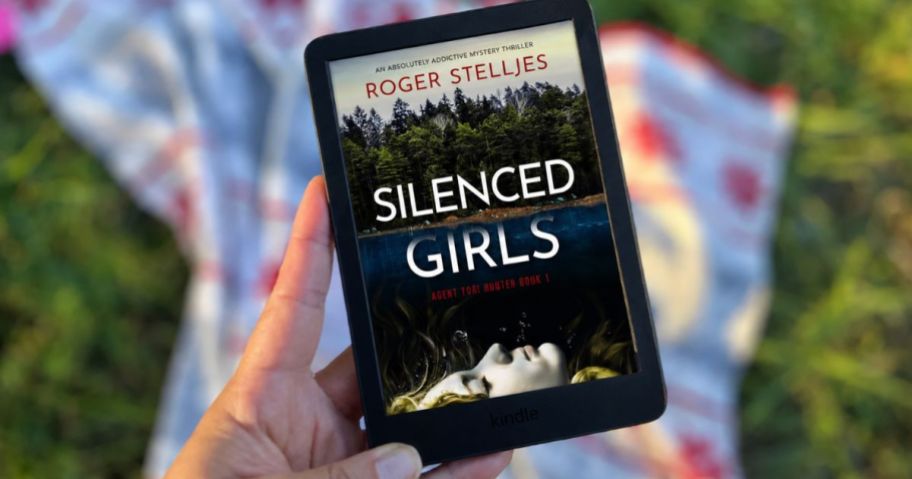 hand holding kindle with the "Silenced Girls" book on it