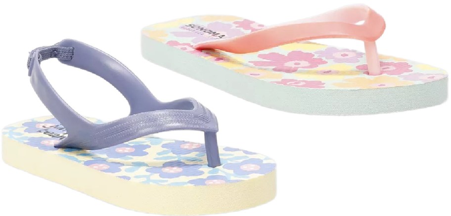 Two floral toddler flip-flops, one with a purple strap and elastic heel strap, and another with a peach strap.