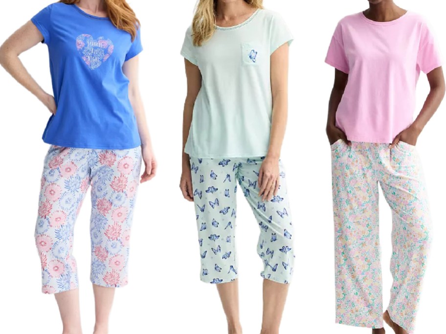 Three women modeling pajama sets side-by-side, wearing a blue graphic t-shirt with patterned capri pants, a light green t-shirt with butterfly capri pants, and a solid pink t-shirt with pastel floral pants.