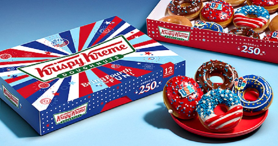 A red, white, and blue themed Krispy Kreme box next to a plate holding four patriotic-decorated donuts with an open box of donuts in the background.