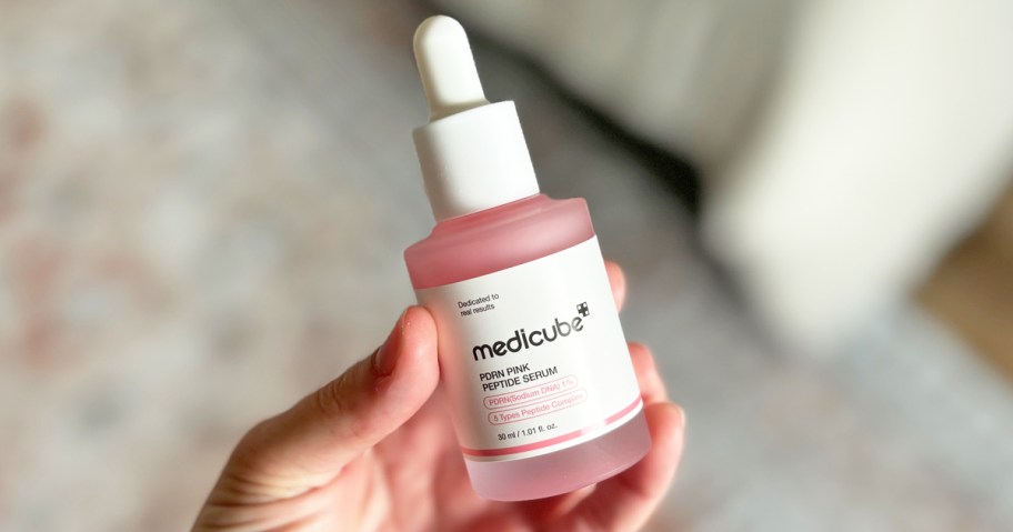 hand holding medicube PDRN Pink Peptide Serum