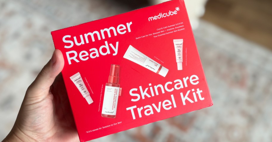 hand holding red box for medicube Summer-Ready Skincare Travel Kit