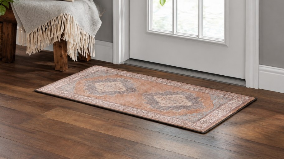 a small persian print accent rug in front of a door