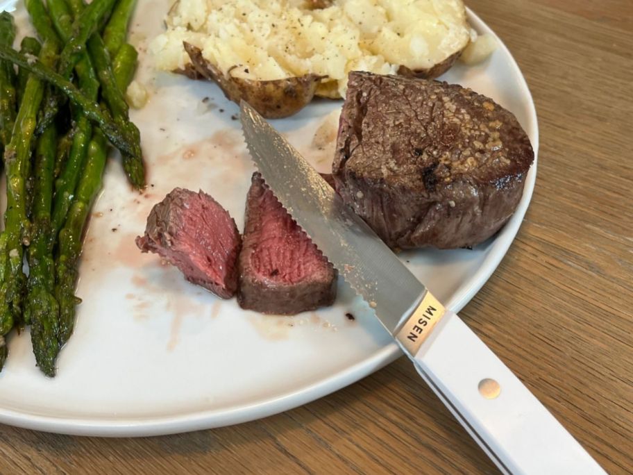 misen Serrated Steak Knife next to cut steak