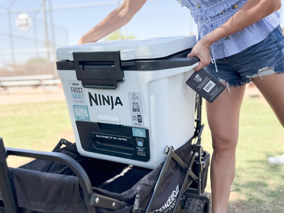 woman loading a Ninja Frostvault cooler onto a wagon