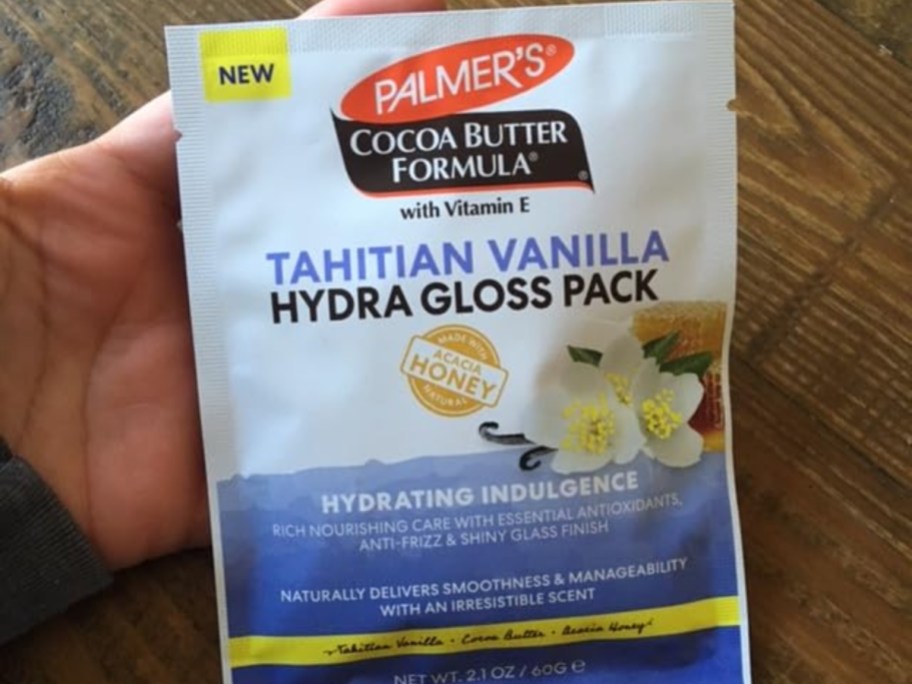 holding a packet of hair gloss
