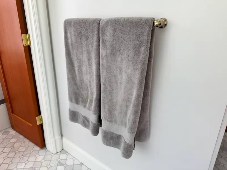 Two plush gray bath towels hanging on handlebar in bathroom
