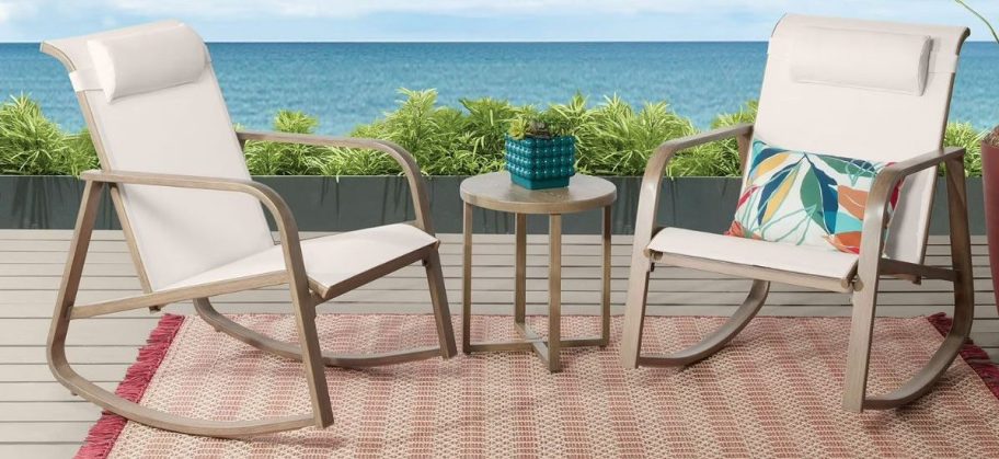 steel rocker patio set displayed outdoors on top of a rug 