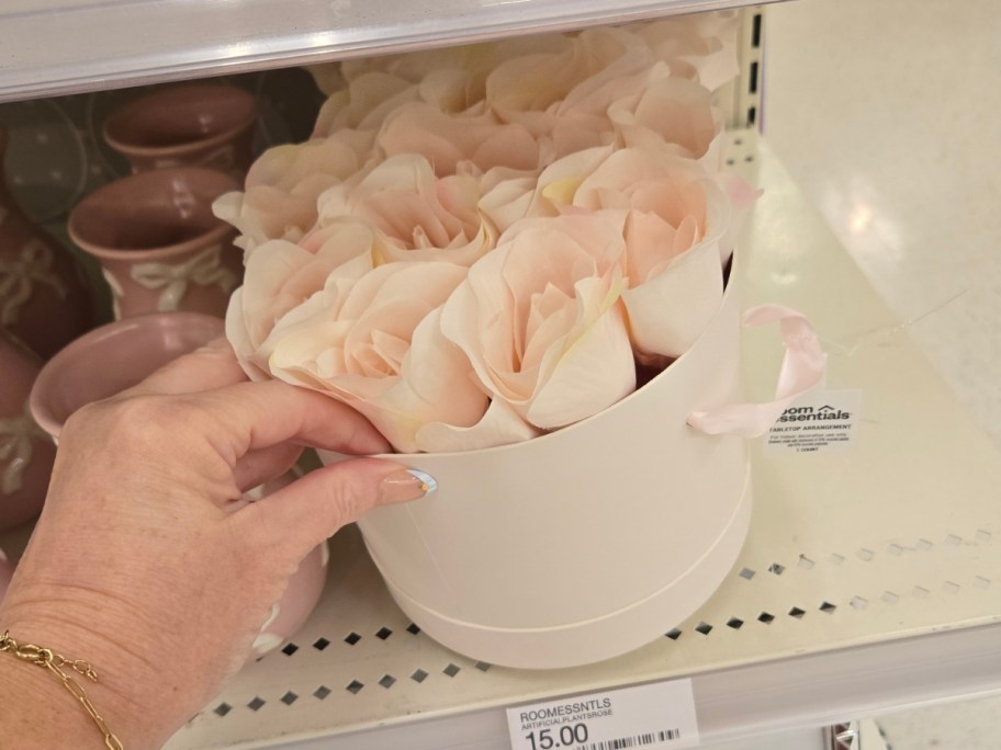 a hand reaching for an artificial rose bouquet