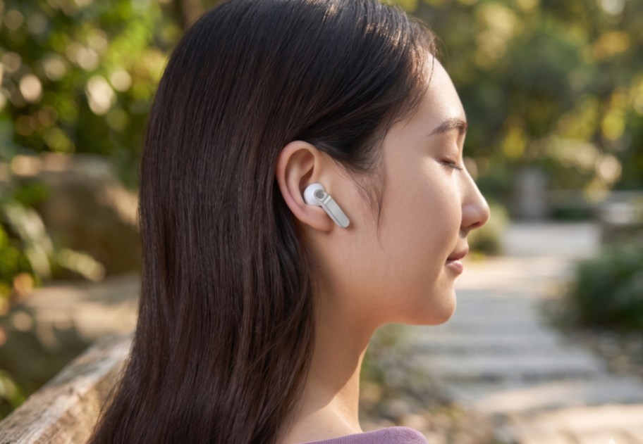 woman outside wearing white earbud