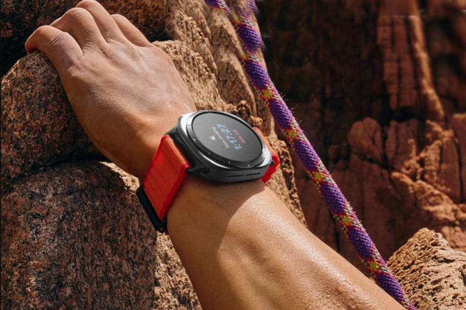 hand rock climbing wearing orange watch