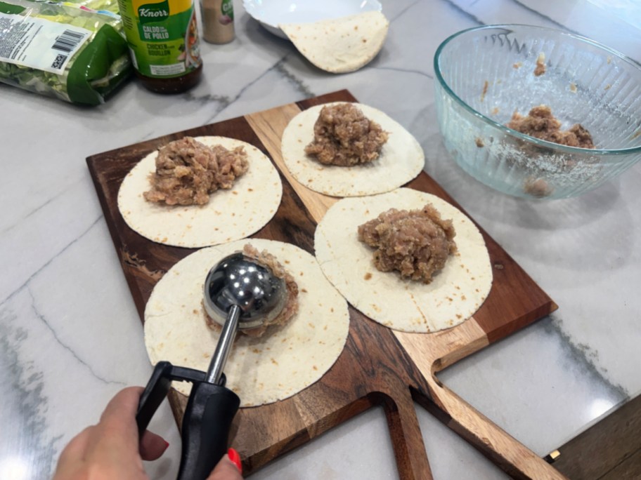 scooping chicken onto tortillas