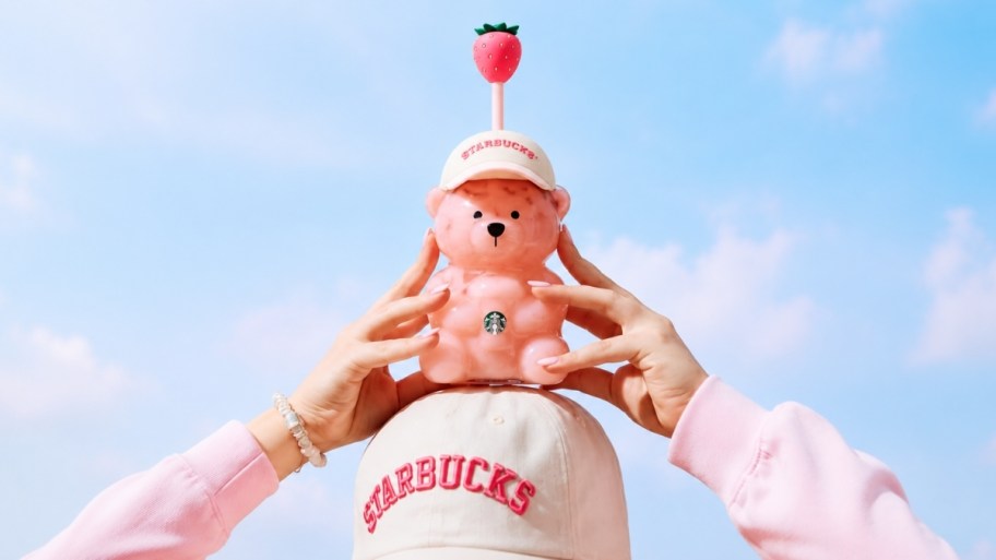 hands holding a starbucks pink bearista cup