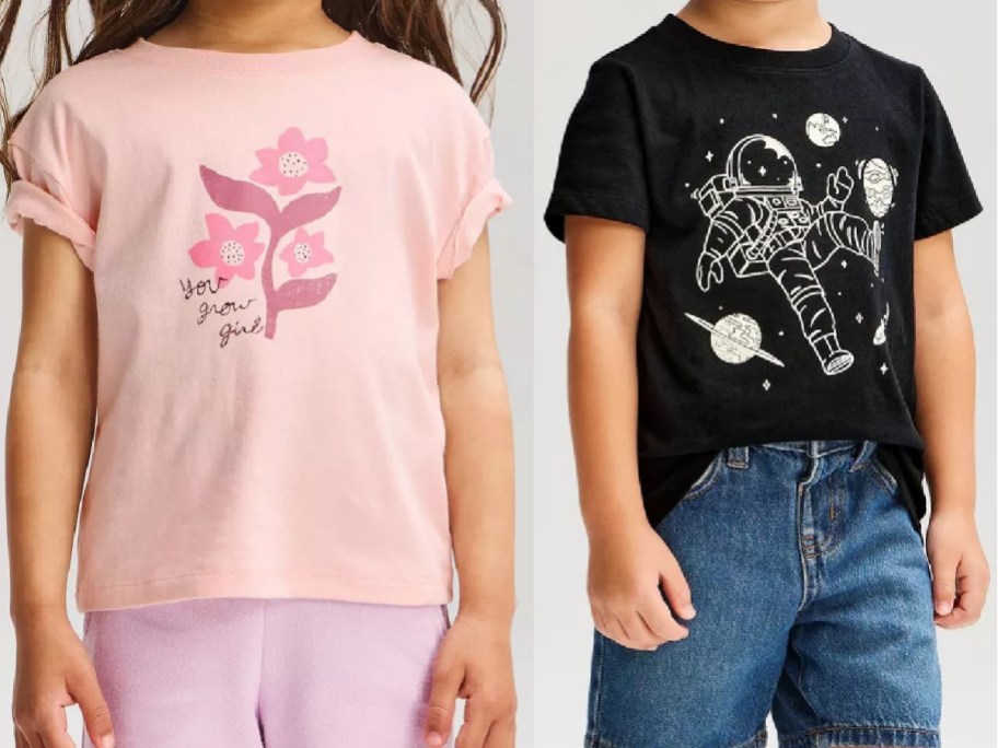 Two styles of children's Cat & Jack graphic t-shirts displayed side by side, featuring a pink short-sleeve shirt with a floral print and "you grow girl" text on the left, and a black short-sleeve shirt with an astronaut and outer space graphic paired with blue denim jeans on the right.