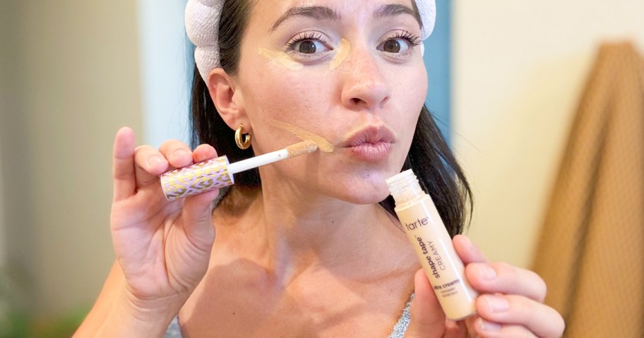 woman applying concealer to her face