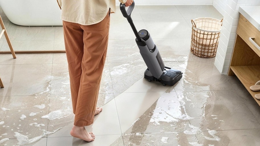 a woman cleaning a floor with the tineco wet/dry vacuum