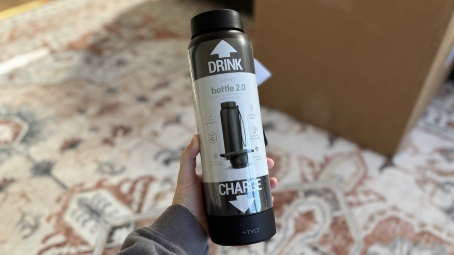 a hand holding a wireless charging power bank water bottle