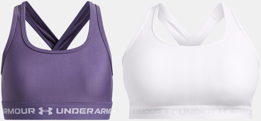 Two sports bras, one in purple with crisscross straps and the other in white with a similar design.
