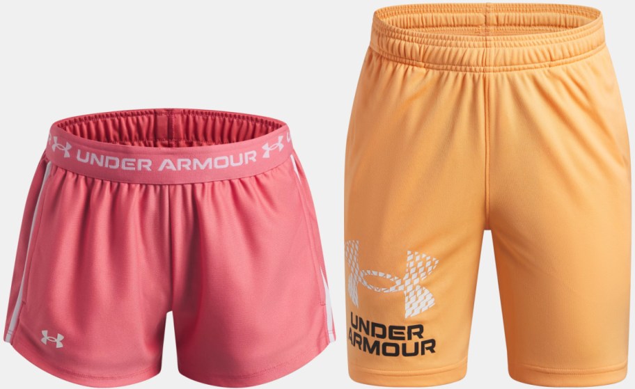 A pair of Under Armour athletic shorts, including pink shorts with a branded waistband and orange shorts with a checkered logo on the leg.