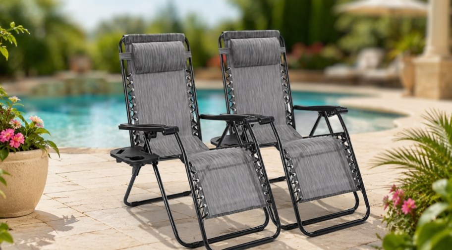 a pair of black zero gravity lounge chairs