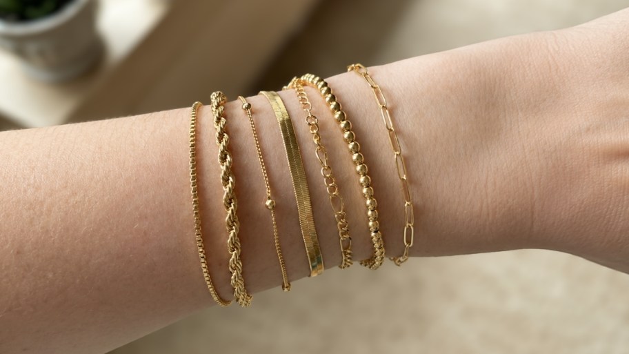 womans wrist wearing a 7 piece bracelet stack