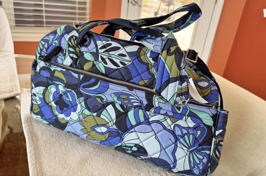 blue floral print quilted duffle bag on a table