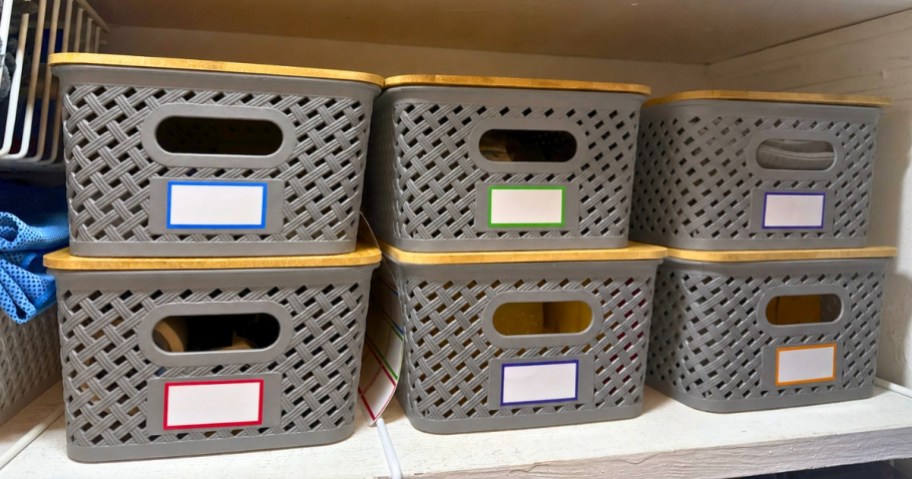 grey plastic storage baskets with bamboo lids on a shelf