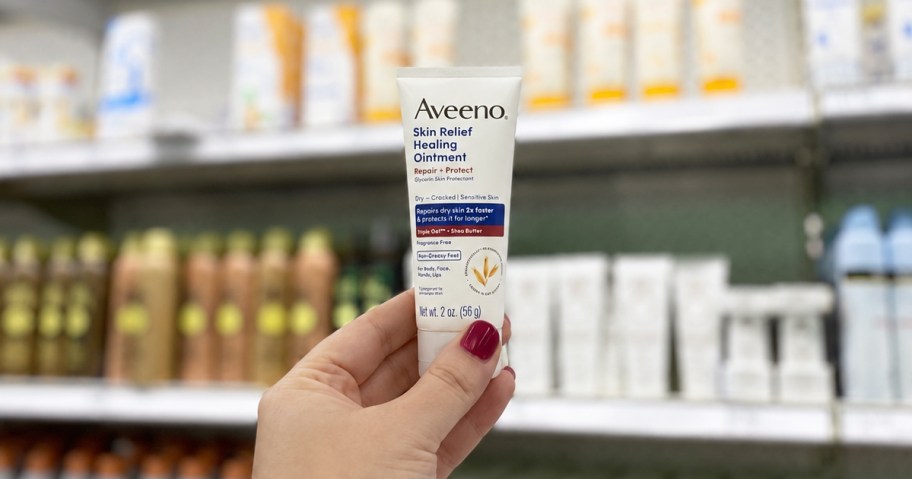 hand holding up a tube of Aveeno Skin Relief Healing Ointment in store aisle