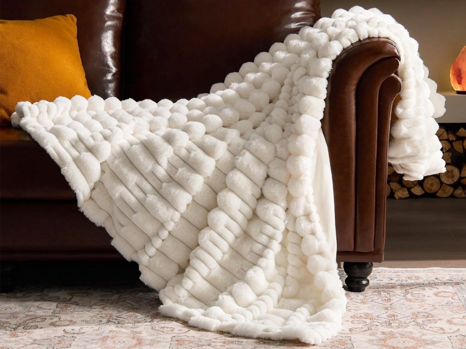 white throw blanket draped over a leather couch