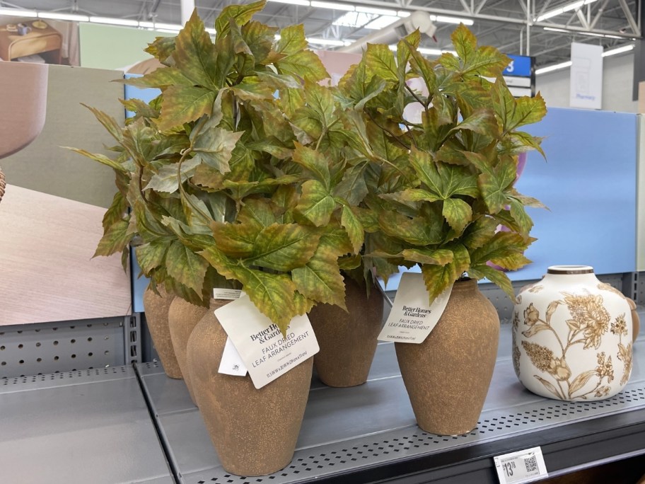 green artificial plants in vases on a store shelf