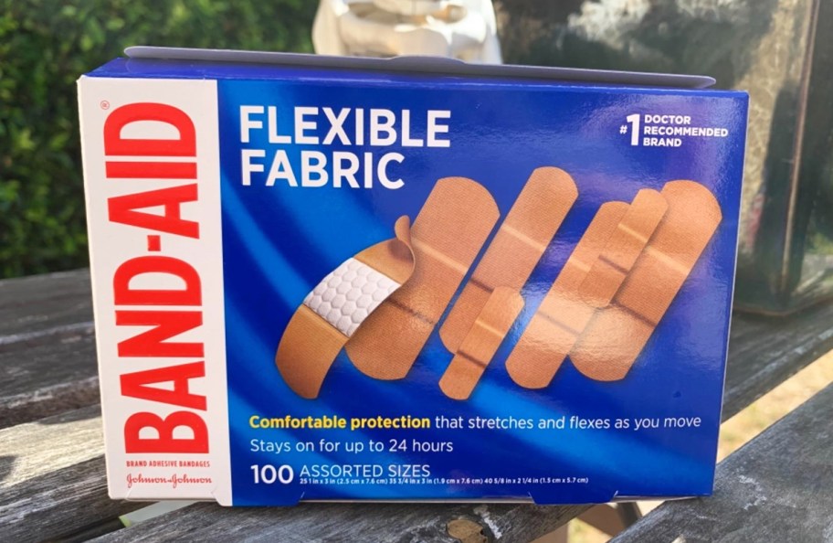 blue box of Band-Aid Flexible Fabric Bandages on a wood table
