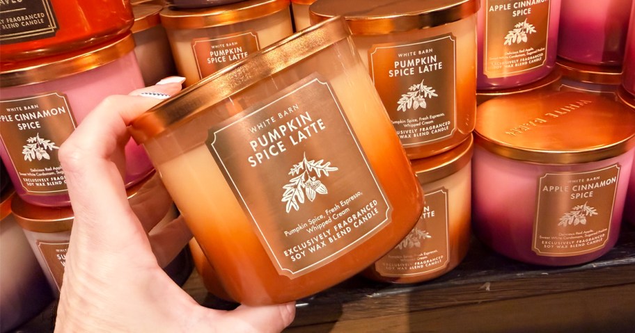 hand holding a pumpkin spice latte scented candle
