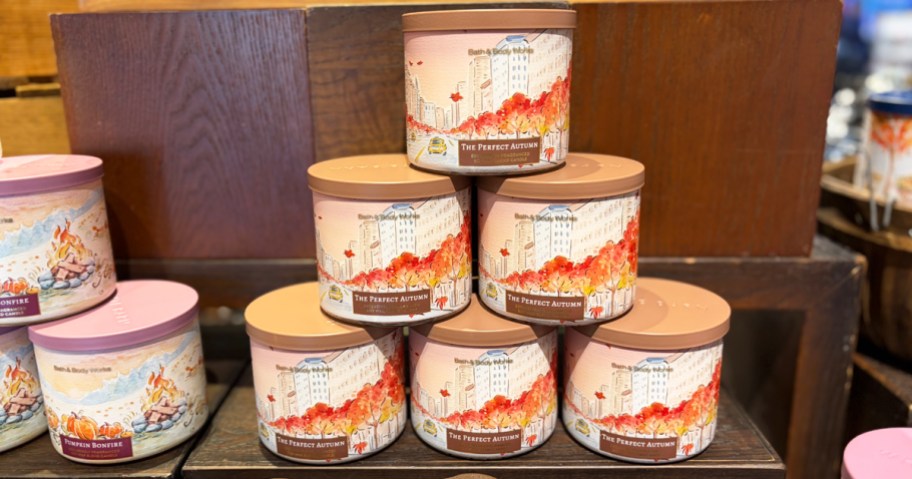 stack of fall scented 3-wick candles on store display