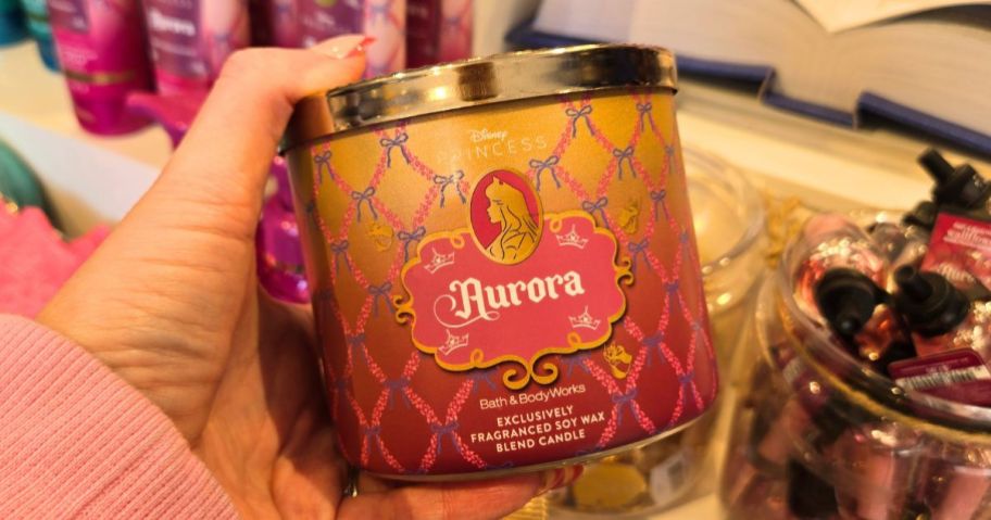 Hand holding a Bath & Body Works Disney Princess Collection Aurora 3-Wick candle